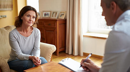 психиатр сидит, консультирует пациента у него дома